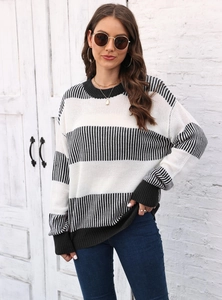 Détail d'un pull en tricot à rayures noires et blanches avec poignets côtelés et col rond
