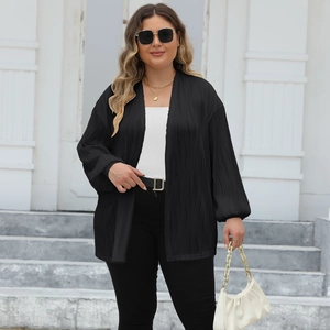 Close-up detail of the black pleated fabric texture and loose lantern sleeves on the cardigan