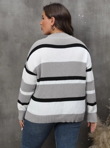 Detail view of women's color-block knit sweater with striped back and ribbed hem texture