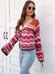 Detail of colorful wavy knit cardigan featuring bell sleeves and tie-front bohemian style
