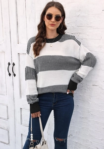 Détail de la texture en maille rayée noire et blanche et du poignet côtelé pour ce pull