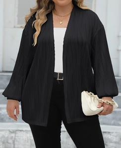 Detail of black pleated cardigan fabric and loose fitting long sleeves on the model