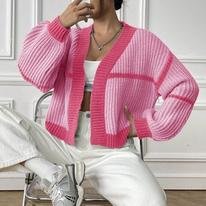 Close-up of pink color-block knit cardigan with textured vertical stripes and V-neckline