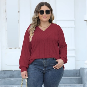 Detail of burgundy ribbed knit V-neck top with crossover neckline and long sleeves