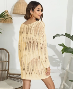 Detailed close-up of geometric hollow crochet knit fabric on a beach bikini cover-up