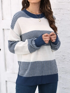 Détail d'un pull en maille rayé bleu et blanc à coupe ample avec col rond pour femme