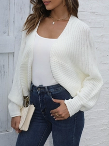 Close-up of white chunky knit cardigan featuring detailed texture and lantern sleeves