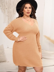 Detail of V-neck knitted dress showing ribbed cuffs and elegant knit texture on sleeve