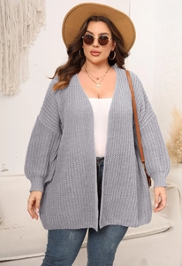 Close-up detail of grey chunky knit cardigan showing thick textured weave and lantern sleeves