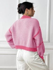 Close-up of pink color-block knitted cardigan with heavy texture and drop shoulder design