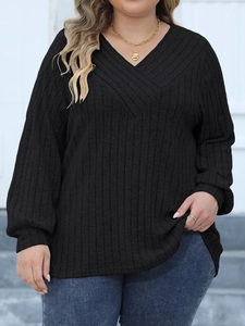 Close-up of black ribbed texture fabric and stylish cross V-neck on a long sleeve top