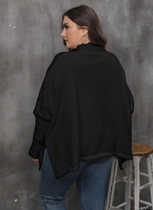 Detail view of oversized black batwing sleeve knit top with side slits and turtleneck