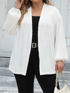 Detail of white pleated cardigan showing vertical wavy texture and elegant lantern sleeves