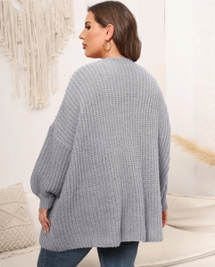Detail view of the gray chunky knit cardigan featuring drop shoulder and lantern sleeves