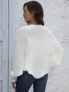 Rear view of white knit sweater featuring irregular batwing sleeves and ribbed texture