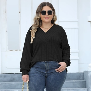 Detail of black ribbed knit plus size sweater featuring a deep V-neck cross design