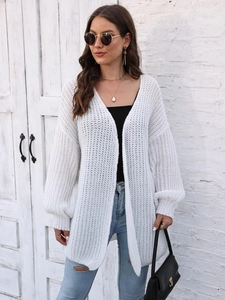 Detail of white oversized chunky knit cardigan with textured drop shoulder lantern sleeves