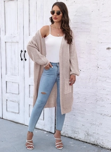 Dettaglio del cardigan lungo beige lavorato a maglia con ampie tasche e maniche a lanterna
