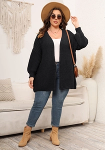 Close-up of black chunky knit cardigan with ribbed cuffs and textured stitch detail