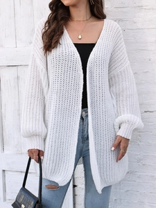 Close-up of white chunky knit cardigan with lantern sleeves and textured stitch detail