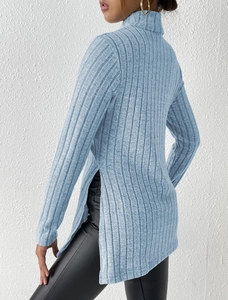 Detail view of light blue turtleneck sweater featuring vertical ribbed texture and side slit