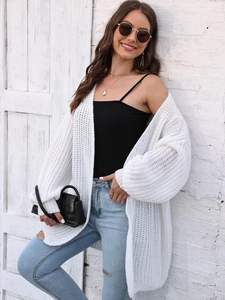 Detailed texture of women's white chunky knit oversized cardigan sweater in a street style