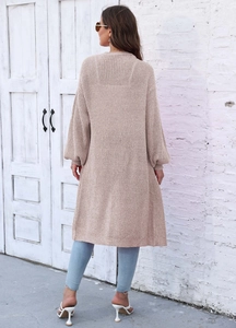 Vista posteriore di un lungo cardigan in maglia beige con taglio oversize e polsini