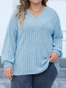 Detail of light blue ribbed V-neck long sleeve top with soft knitted texture and drop shoulder
