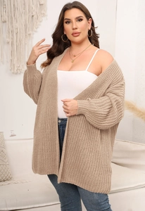 Detailed knit texture of beige oversized cardigan sweater for women in cozy home setting