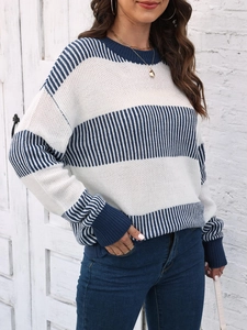 Détail d'un pull en tricot à col rond avec rayures bleues et blanches et poignets côtelés