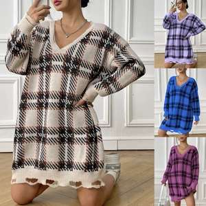 Detail of oversized V-neck knit dress with plaid pattern and distressed hem finish