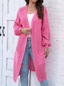 Dettaglio del cardigan rosa in maglia con trama spessa, grandi tasche e maniche a lanterna
