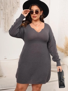 Detail of grey plus-size V-neck knit dress showing scalloped edges and cutout sleeve patterns