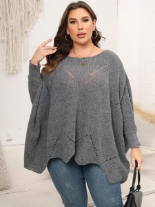 Detail eines grauen Oversize-Strickpullovers mit modischem V-förmigem Durchbruchmuster