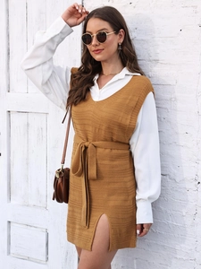 Detail of knit vest dress with side slit and matching waist belt over a white shirt