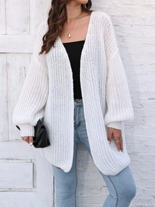 Detail of white chunky knit cardigan featuring hollow weave texture and lantern sleeves