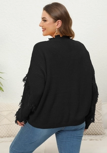 Detail of black knit sweater with decorative fringe on sleeves and ruffled neck design