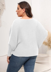 Detail of white oversized knitted sweater featuring batwing sleeves and ribbed texture