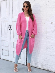 Dettaglio della trama a maglia grossa e delle grandi tasche su un cardigan lungo rosa
