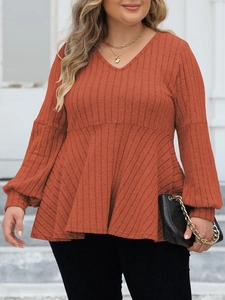 Detail of V-neck ribbed knit texture and puff lantern sleeves on a terracotta orange top