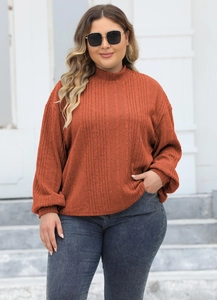 Detail of brick red ribbed knit texture and mock neck design on this oversized sweater