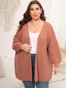 Close-up of pink chunky knit cardigan featuring cozy lantern sleeves and textured stitch pattern