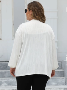 Detail of white oversized cardigan showing unique wave texture and relaxed long sleeve fit