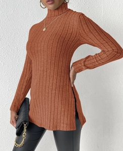 Detail of caramel turtleneck sweater showing ribbed texture and stylish side slit hem
