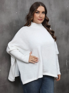 Detail of white knit poncho top with a mock neck and loose batwing sleeve texture