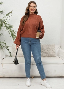 Detail of rust-red cable knit sweater featuring puff sleeves and high-neck texture