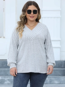 Macro detail of grey ribbed knit fabric and cross V-neck design on plus size top