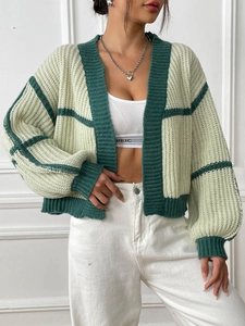 Detail of the chunky knit texture and striped ribbing on a loose cardigan sweater