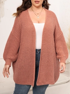 Detail of chunky knit texture on pink plus-size cardigan with elegant lantern sleeves