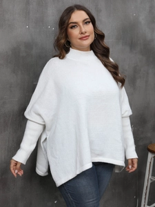 Close-up of white oversized knit sweater with high neck and batwing sleeve details